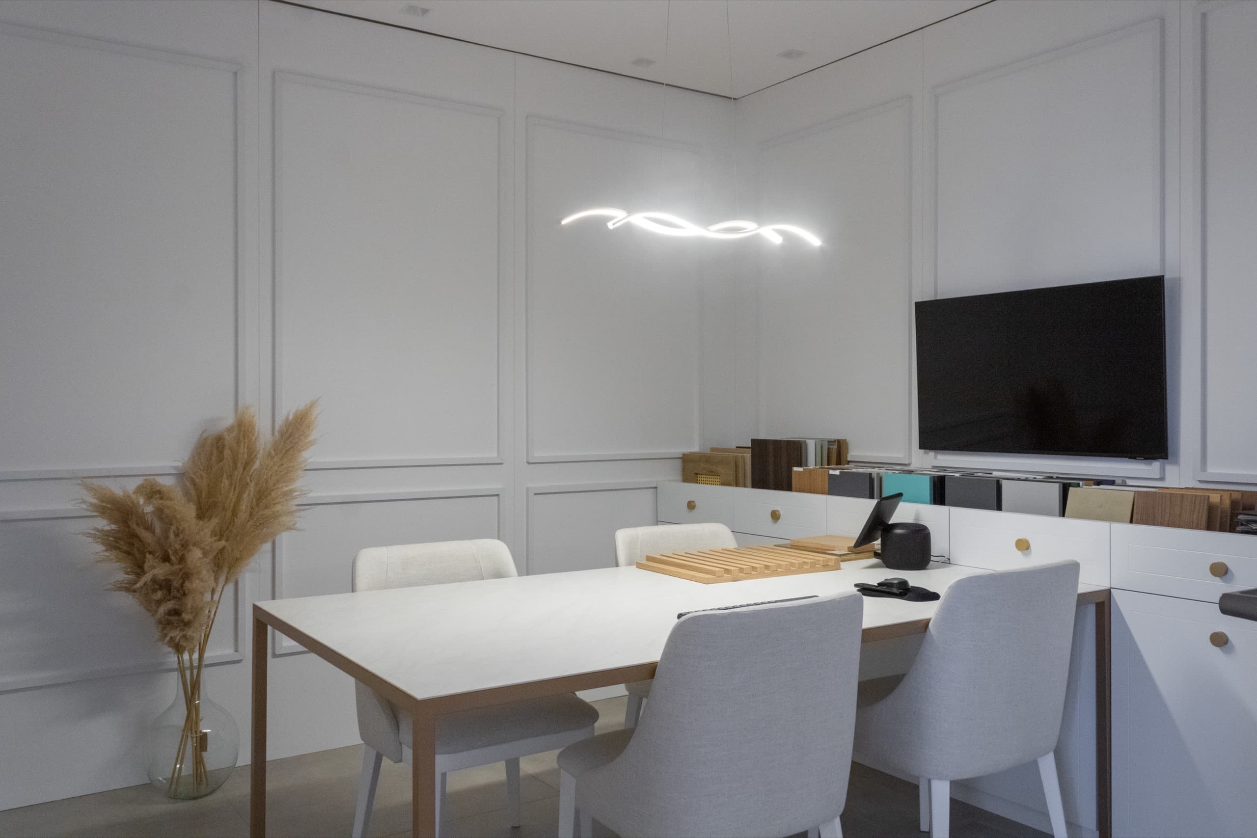 Sala de apresentações do showroom Borelli em Xangri-Lá, com mostruário de materiais e mesa de reunião